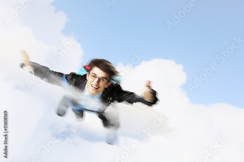 Photo: Young businessman flying with parachute on back Young businessman flying with parachute on back