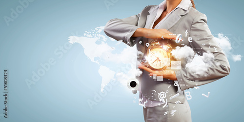 Photo: Business man holding alarmclock Business man holding alarmclock