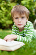 kleiner junge liest im garten