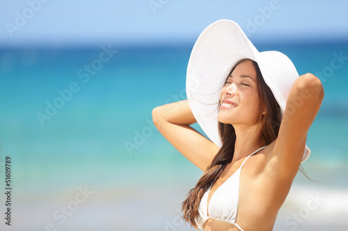 Photo: Relaxing beach woman enjoying the summer sun happy Relaxing beach woman enjoying the summer sun happy