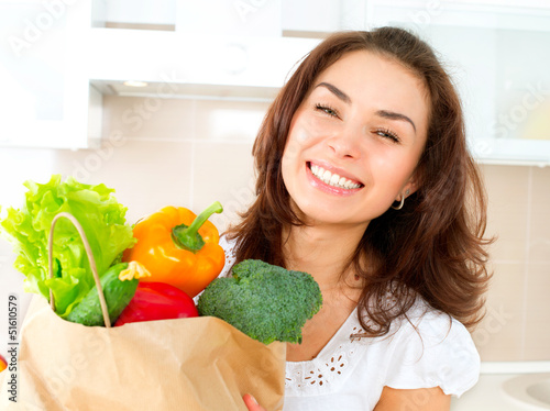 Photo: Happy Young Woman with vegetables in shopping bag. Diet Concept Happy Young Woman with vegetables in shopping bag. Diet Concept