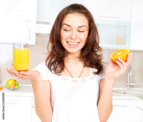 Photo: Young and Healthy Woman with Orange Juice in the Kitchen Young and Healthy Woman with Orange Juice in the Kitchen