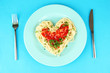 Cooked spaghetti carefully arranged in  heart shape and topped