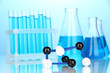 Molecule model and test tubes with liquid on blue background