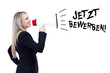 Blonde Frau lächelt durch das Megaphone Jetzt bewerben