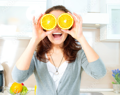 Photo: Funny Woman with Orange over Eyes in the Kitchen Funny Woman with Orange over Eyes in the Kitchen