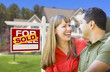 Couple in Front of Sold Real Estate Sign and House