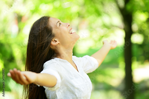 Photo: Young woman rejoicing in a spring or summer garden Young woman rejoicing in a spring or summer garden