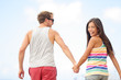 Happy cheerful young trendy couple holding hands