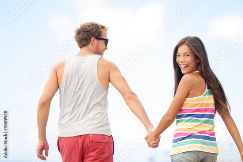 Photo: Happy cheerful young trendy couple holding hands Happy cheerful young trendy couple holding hands