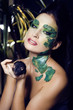 woman with creative make up like snake with rat in her hands