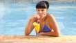 beautiful woman relaxing in swimming pool with cocktails