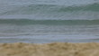 Tidal waves crushing against sandy beach.