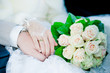 Hands and rings on wedding bouquet