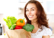 Happy Young Woman with vegetables in shopping bag