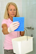 Frau putzt die  Dusche mit Putzlappen