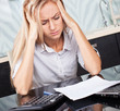 Sad woman looks at the bill