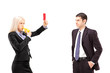 Young woman in a suit showing a red card and blowing a whistle t