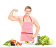 Sexy muscular man wearing a red apron and preparing a salad