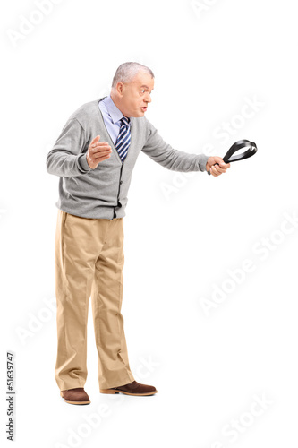 Photo: Full length portrait of an angry mature man holding a belt and t Full length portrait of an angry mature man holding a belt and t