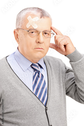 Photo: Portrait of a mature gentleman with headache looking at camera Portrait of a mature gentleman with headache looking at camera