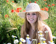 Lachende Frau mit Hut in Sommerwiese