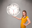 Attractive lady holding a huge clock