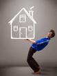 Young boy holding a huge drawn house