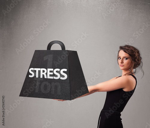 Photo: Young woman holding one ton of stress weight Young woman holding one ton of stress weight