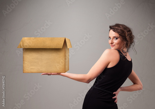 Photo: Young woman holding an empty cardboard box Young woman holding an empty cardboard box