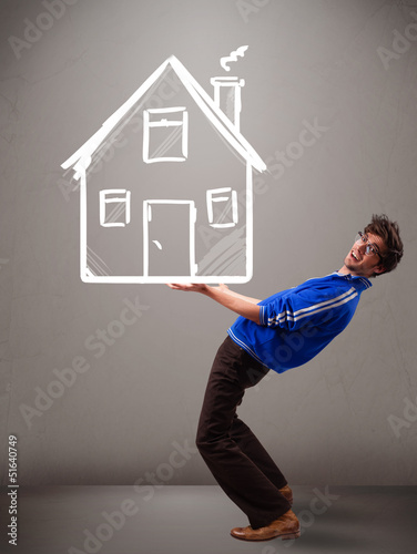 Photo: Young boy holding a huge drawn house Young boy holding a huge drawn house