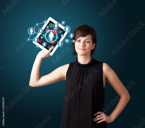 Photo: young woman holding tablet with social network icons young woman holding tablet with social network icons