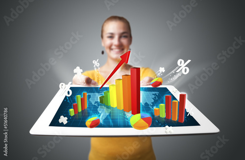 Photo: Young woman holding tablet with colorful graphs and diagrams Young woman holding tablet with colorful graphs and diagrams