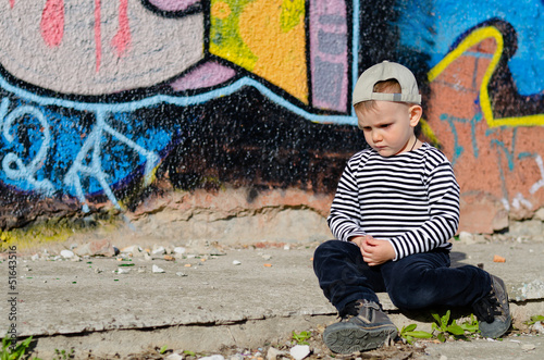 Photo: Small boy sitting thinking or sulking Small boy sitting thinking or sulking
