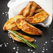 Roasted potatoes with herbs and salt on a board slate