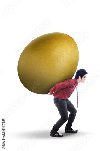 Photo: Businessman carry gold egg on white Businessman carry gold egg on white