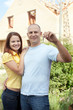 Happy couple against building new house