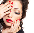 Foto: Model with red nails, lips and creative eye makeup Model with red nails, lips and creative eye makeup