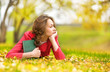 Young beautiful woman lays on a grass with the book 