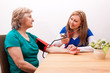 Pflegerin misst Seniorin den blutdruck
