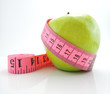 Green apple with pink measuring tape isolated on white backgroun