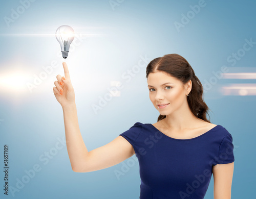 Photo: woman pointing her finger at light bulb woman pointing her finger at light bulb