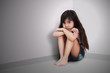 Sad little girl sitting on the floor