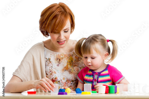 Photo: Happy kid girl and mother playing with colorful clay toy Happy kid girl and mother playing with colorful clay toy