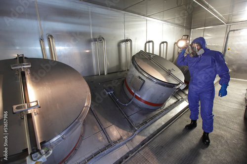 Photo: Technician in mask,with torch, checking tech system Technician in mask,with torch, checking tech system