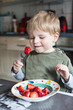 Little boy eating fresh strawberries