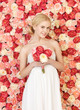 Photo: woman with bouquet and background full of roses woman with bouquet and background full of roses