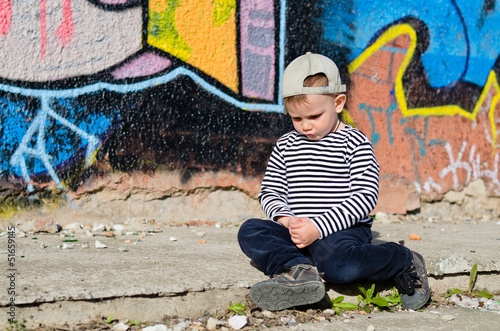 Photo: Little boy sitting sulking Little boy sitting sulking