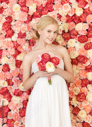 Photo: woman with bouquet and background full of roses woman with bouquet and background full of roses