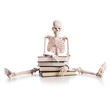 Skeleton with books isolated on white